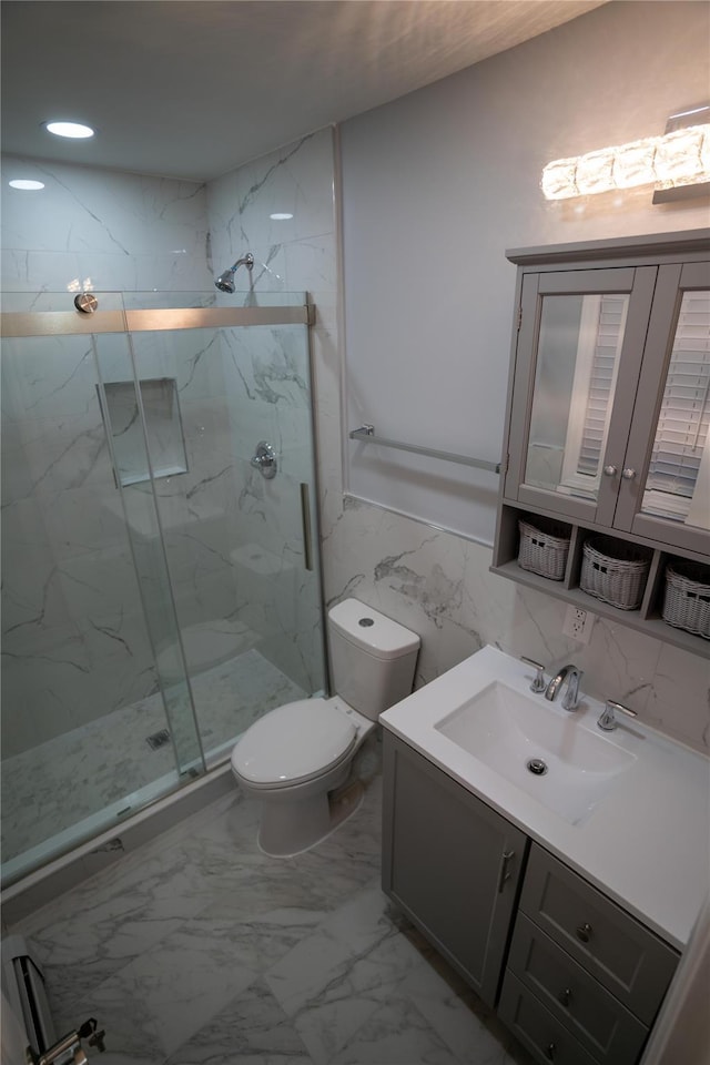 bathroom featuring vanity, a shower with shower door, tile walls, and toilet