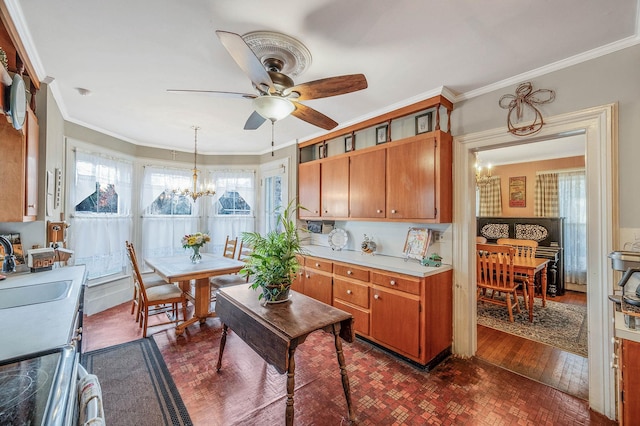 kitchen featuring decorative light fixtures, ceiling fan with notable chandelier, crown molding, and sink