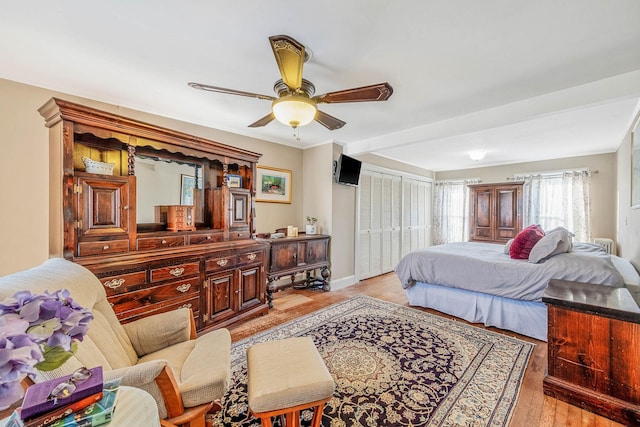 bedroom with ceiling fan, light hardwood / wood-style flooring, and a closet