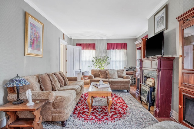 living room featuring a fireplace, ornamental molding, and hardwood / wood-style flooring