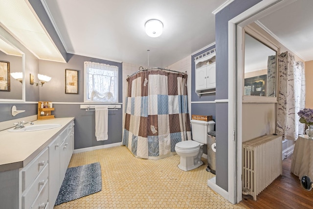 bathroom featuring toilet, walk in shower, radiator, ornamental molding, and vanity