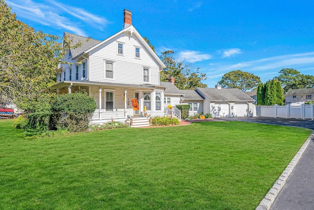 view of front of home featuring a porch, a front lawn, and a garage