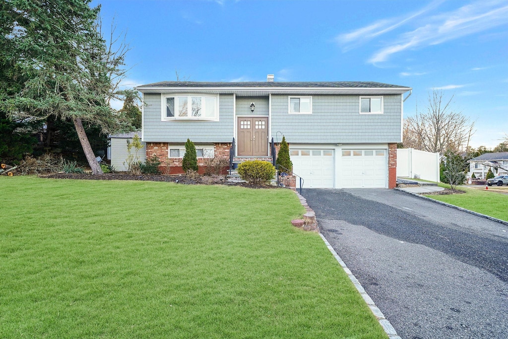 split foyer home with a front yard and a garage