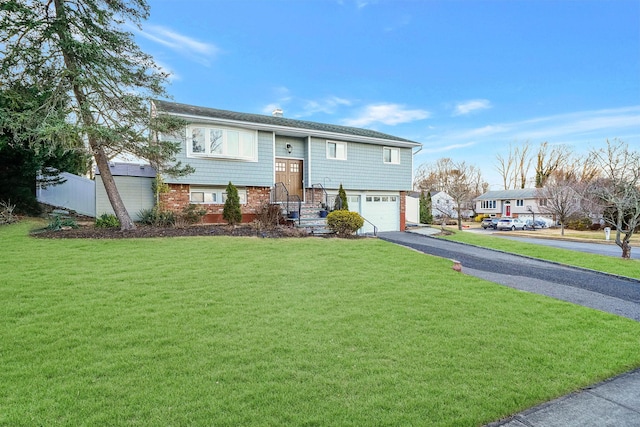 raised ranch featuring a front lawn and a garage