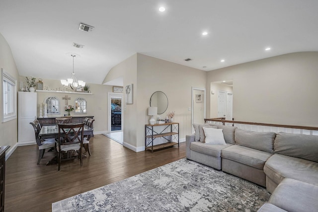 living room featuring a notable chandelier, dark hardwood / wood-style flooring, and lofted ceiling