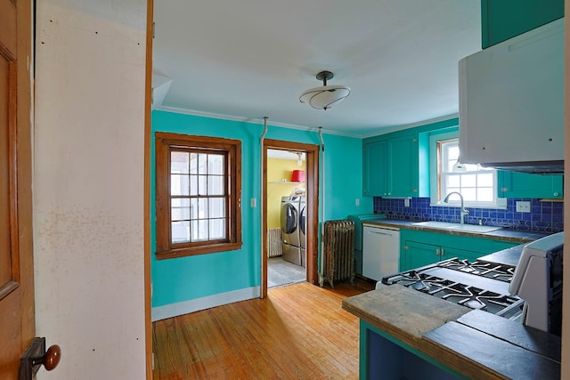 kitchen with white appliances, sink, ornamental molding, light hardwood / wood-style flooring, and radiator heating unit