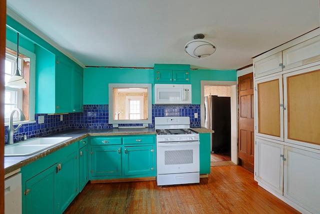 kitchen featuring sink, light hardwood / wood-style floors, tasteful backsplash, and white appliances