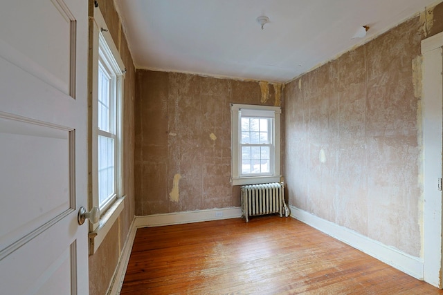 empty room with radiator and light wood-type flooring