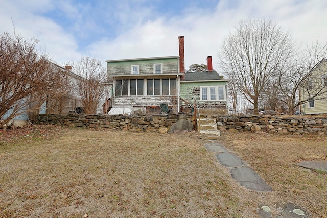 back of house with a sunroom and a yard