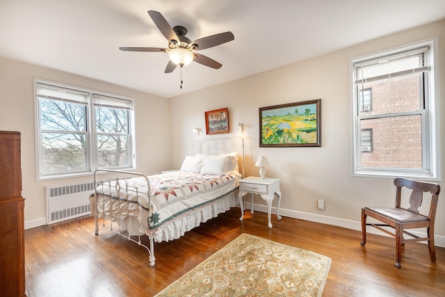 bedroom with radiator, ceiling fan, and wood-type flooring