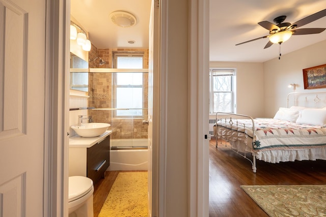 bedroom with ceiling fan, dark hardwood / wood-style floors, and sink