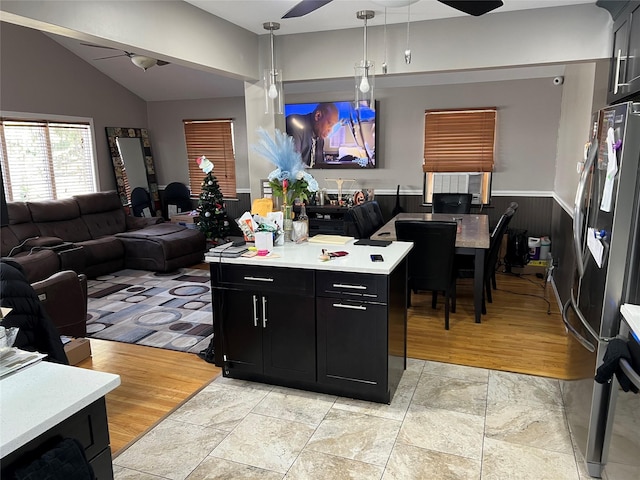 kitchen featuring lofted ceiling, light hardwood / wood-style flooring, stainless steel fridge, pendant lighting, and ceiling fan