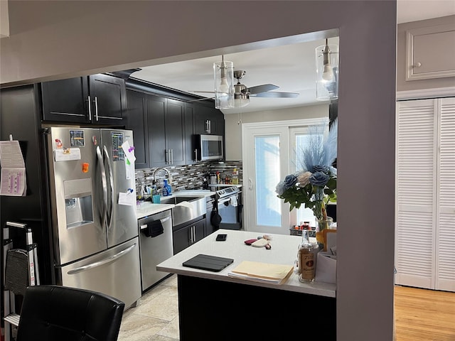 kitchen with appliances with stainless steel finishes, backsplash, ceiling fan, and sink