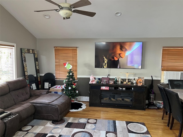 living room featuring light wood-type flooring, vaulted ceiling, ceiling fan, and cooling unit