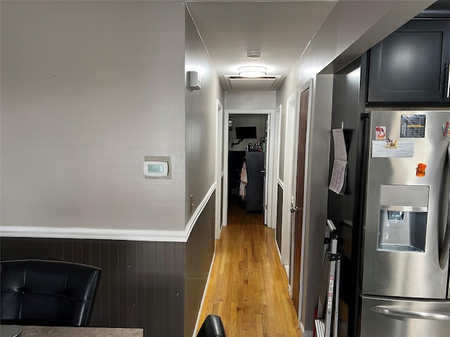 hall with wooden walls and light wood-type flooring