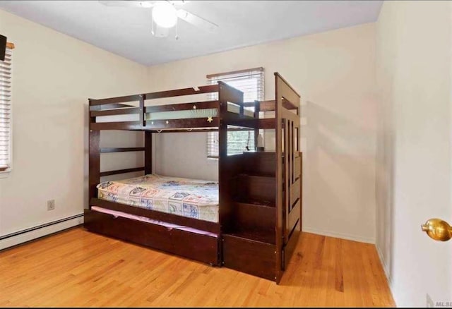 bedroom featuring ceiling fan, wood-type flooring, and baseboard heating