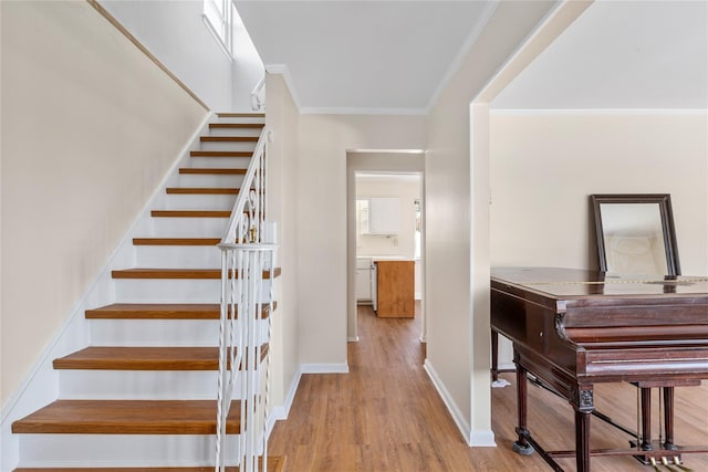 stairs with hardwood / wood-style flooring and ornamental molding