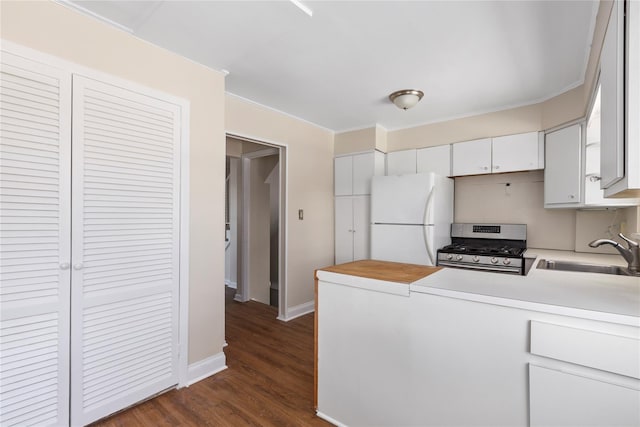 kitchen featuring dark hardwood / wood-style floors, gas stove, sink, white cabinetry, and white refrigerator