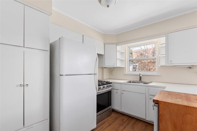 kitchen featuring white fridge, sink, white cabinetry, dark hardwood / wood-style flooring, and gas range