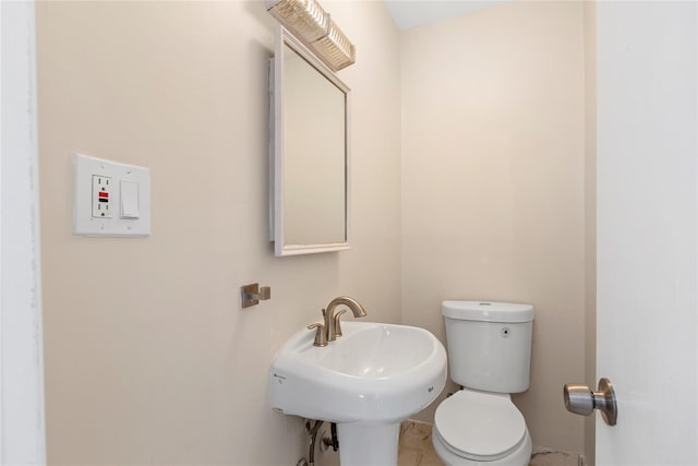 bathroom with toilet, tile patterned flooring, and sink