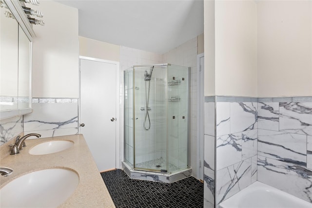 bathroom featuring vanity, tile walls, tile patterned floors, and a shower with door