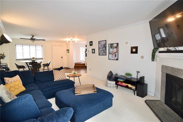 living room featuring carpet flooring, ceiling fan, and crown molding