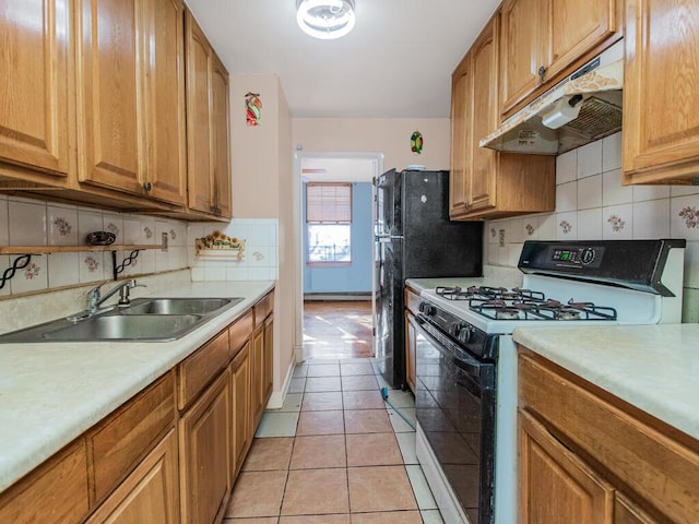 kitchen with white range with gas cooktop, decorative backsplash, sink, and light tile patterned floors