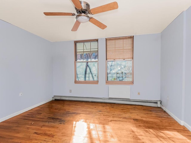 empty room featuring baseboard heating, ceiling fan, and hardwood / wood-style flooring