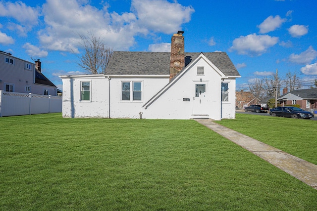 rear view of property with a lawn