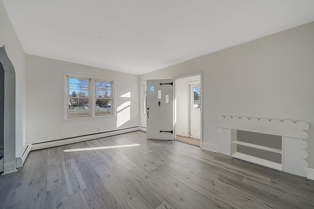 interior space with wood-type flooring and a baseboard heating unit