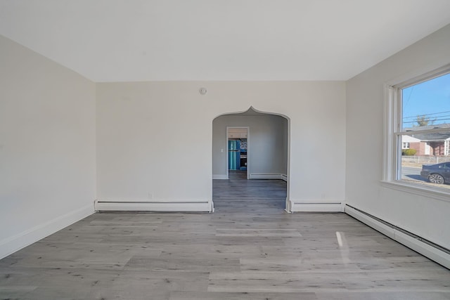 empty room with light hardwood / wood-style flooring and a baseboard radiator