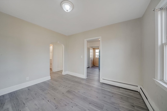 spare room with light wood-type flooring and a baseboard radiator