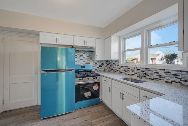 kitchen featuring sink, decorative backsplash, appliances with stainless steel finishes, light stone counters, and white cabinetry