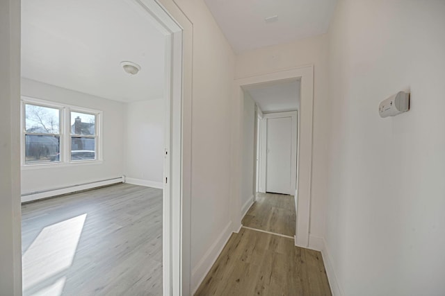 corridor featuring light hardwood / wood-style flooring and baseboard heating