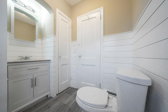 bathroom featuring wood-type flooring, vanity, and toilet