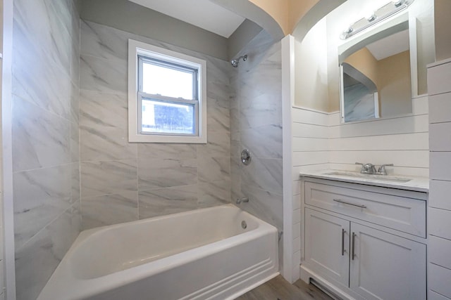 bathroom featuring vanity, tiled shower / bath combo, and hardwood / wood-style flooring