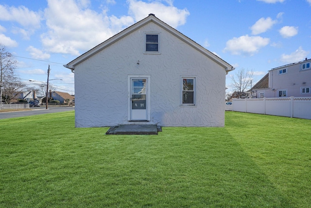 rear view of property featuring a lawn