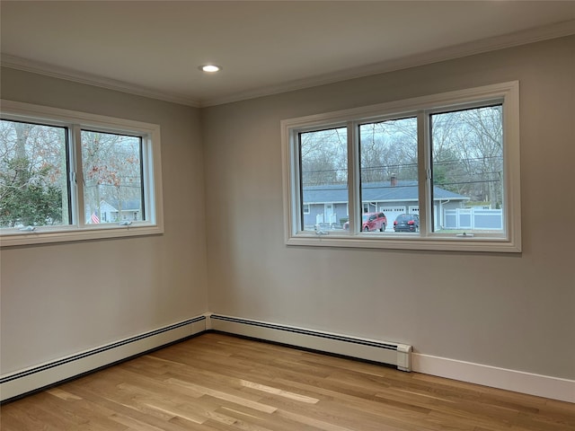 spare room with a wealth of natural light, crown molding, and light hardwood / wood-style flooring