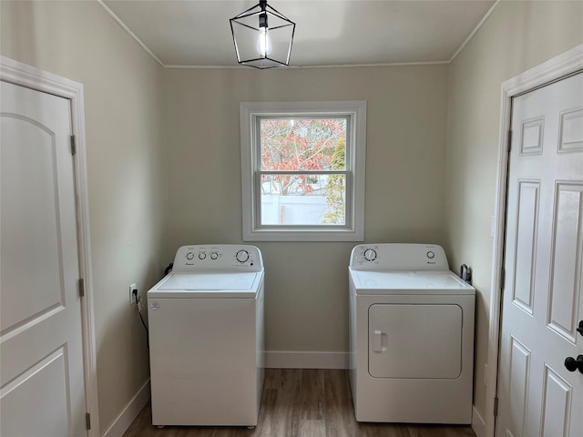 clothes washing area with hardwood / wood-style floors and independent washer and dryer