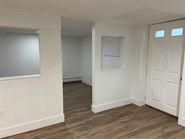 empty room with dark hardwood / wood-style flooring and a baseboard radiator