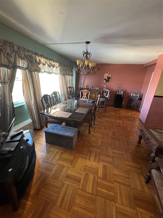 dining area with dark parquet floors and a notable chandelier