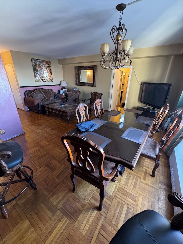 dining space with an inviting chandelier and parquet floors