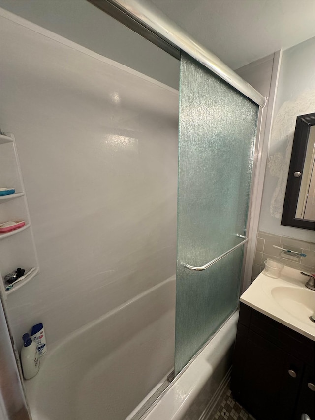 bathroom with shower / bath combination with glass door, decorative backsplash, vanity, and tile walls