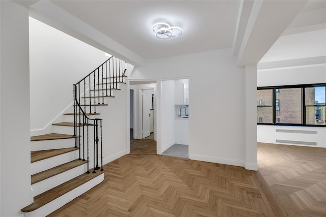 stairway featuring parquet flooring and sink