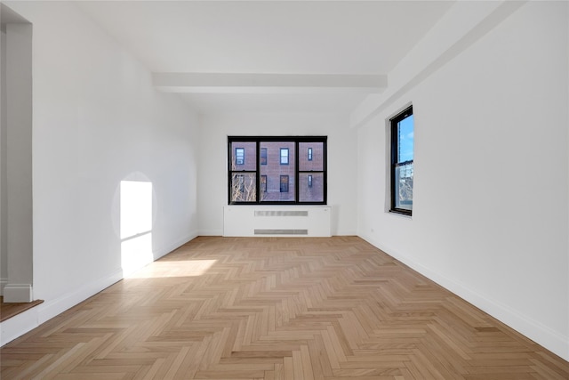 unfurnished room featuring beam ceiling, radiator, and light parquet flooring