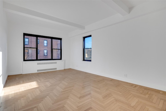 spare room featuring beam ceiling, radiator, and light parquet flooring