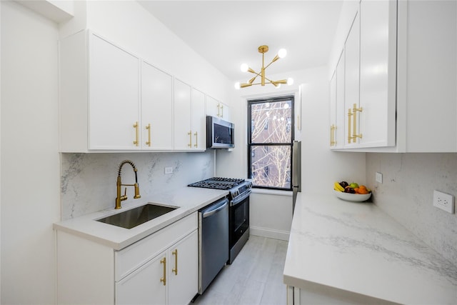 kitchen with backsplash, sink, white cabinetry, and stainless steel appliances