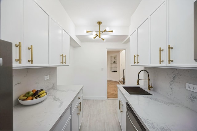 kitchen with white cabinets, sink, stainless steel dishwasher, decorative backsplash, and light stone countertops