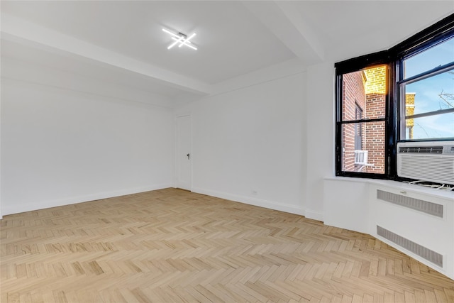 spare room with cooling unit, beam ceiling, radiator heating unit, and light parquet floors