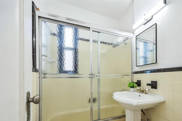 bathroom featuring walk in shower and tile walls